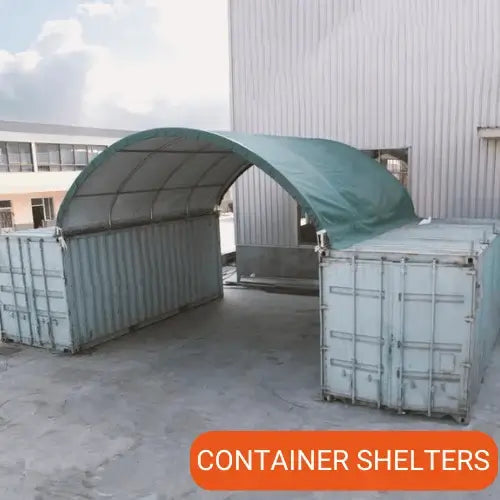 Container shelter with a green cover in front of a building