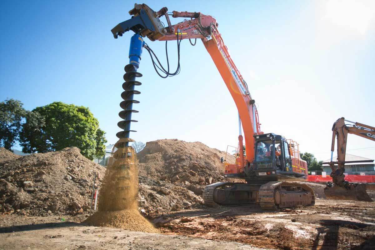 Auger S2- Length 900mm in use with micro excavator, drilling into soil at a construction site.