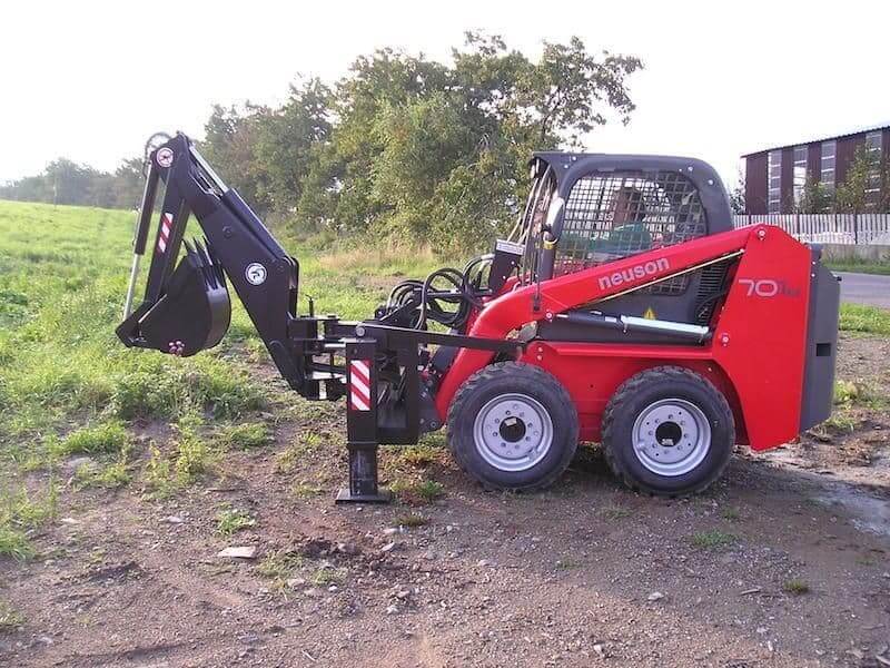 Kovaco Backhoe Bucket attached to a red skid-steer loader, ideal for landscaping and construction work.